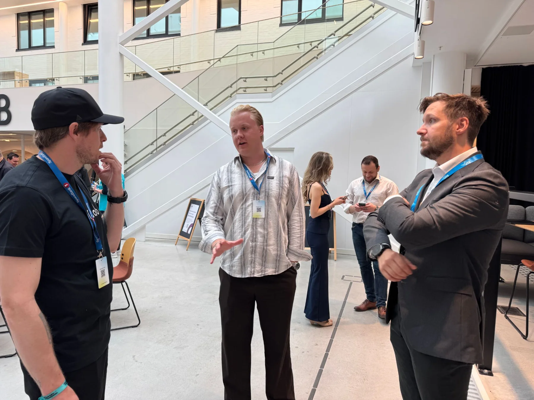 Andreas Myraune i samtale med to deltakere i foajeen på InnoCamp etter pitchen